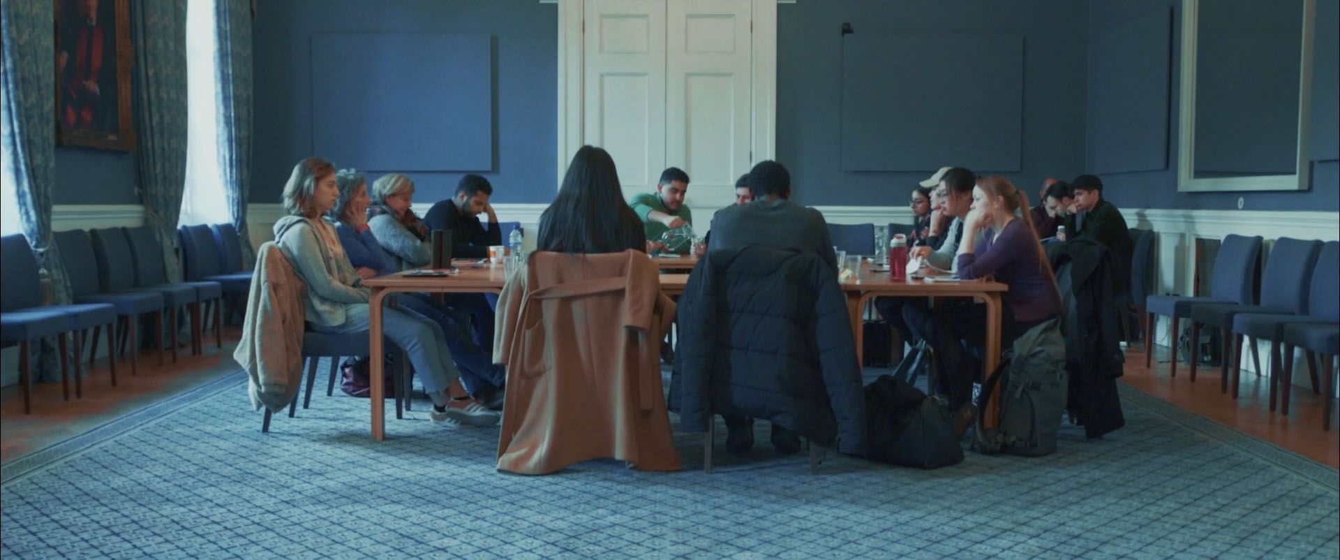 In making The Justice Syndicate, Fast Familiar thought carefully about the ethics of interactive theatre. Here, a theatre audience of twelve people sit around a table in a grand-looking room.